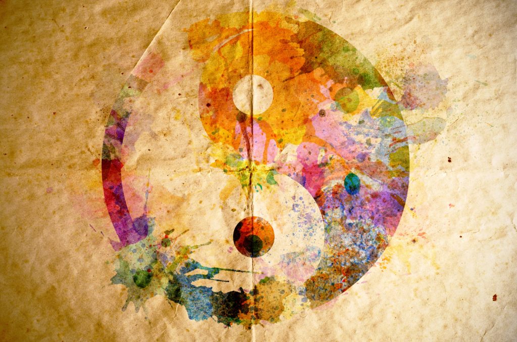 Watercolor yin-yang symbol painted over creased, aged paper