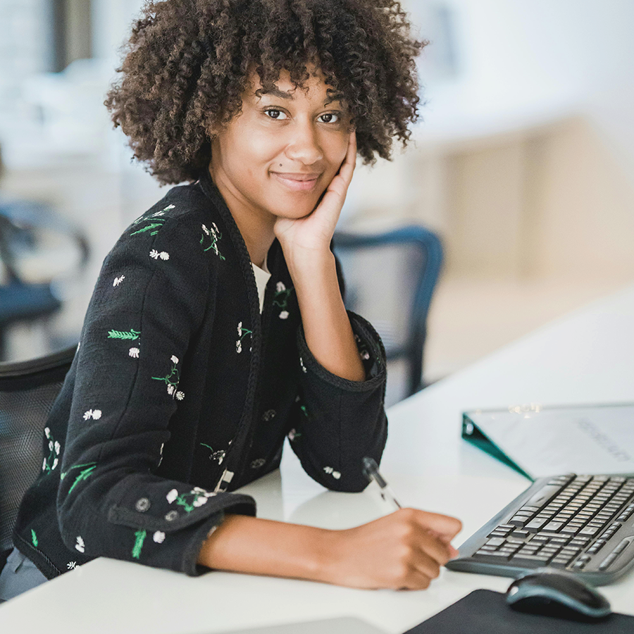 Professional woman working on SAP BTP strategy consulting at laptop in modern office environment