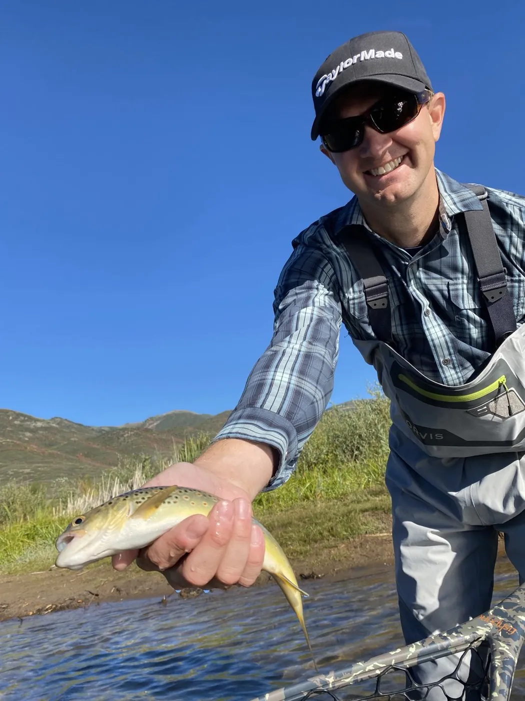 Jon Bragg holding a brown trout on the river during a Mindset product retreat in Park City